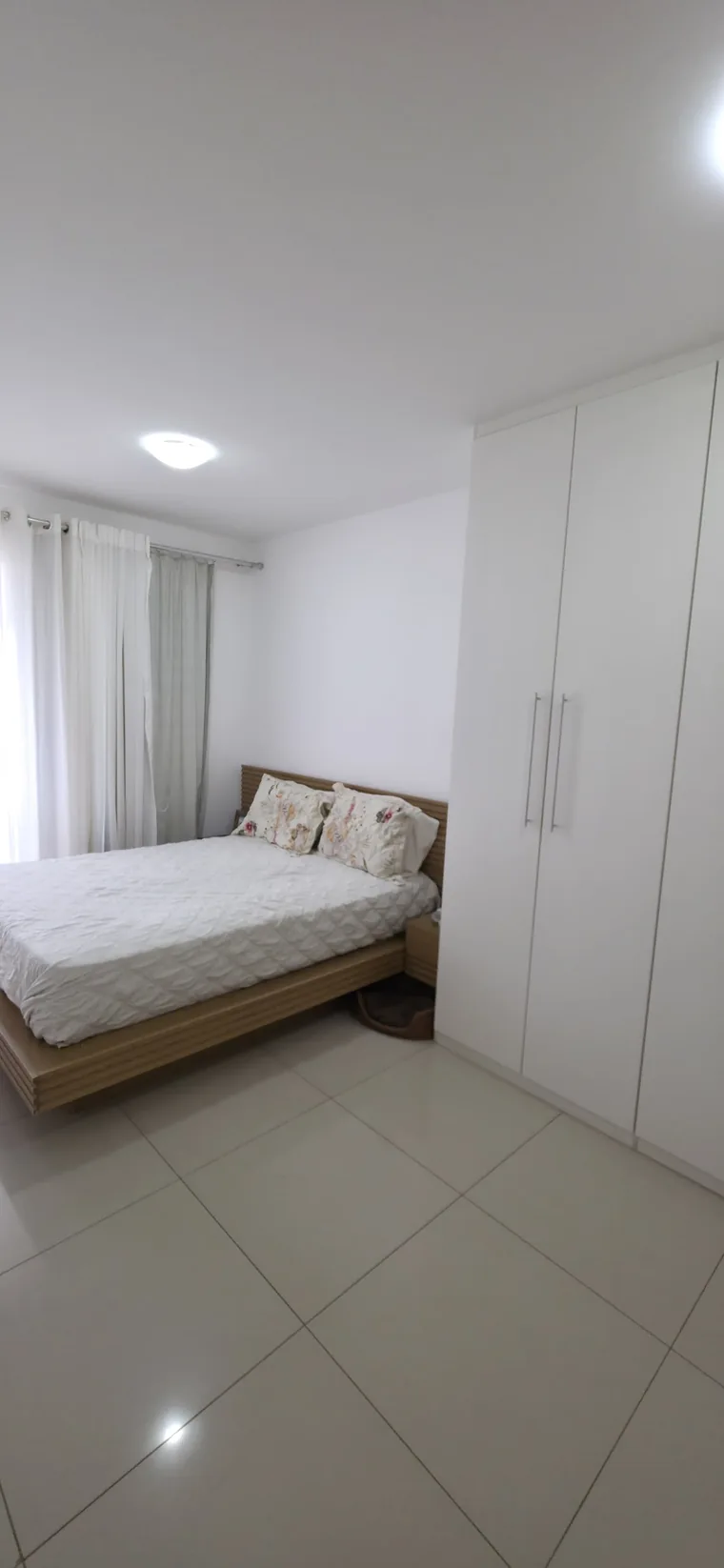 Quarto com cama de casal e iluminação natural