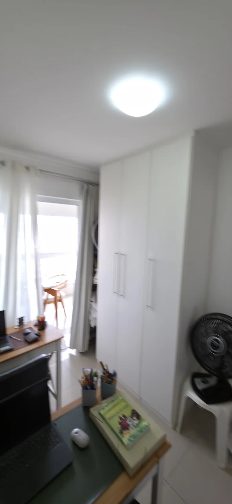 Segundo quarto do apartamento com mesa de trabalho