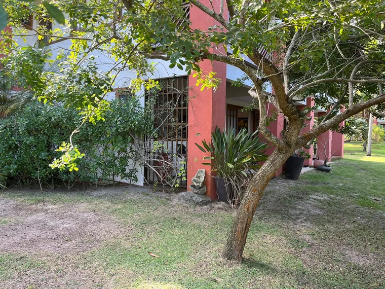 Fachada do apartamento Reserva Timeantube entre árvores e jardim