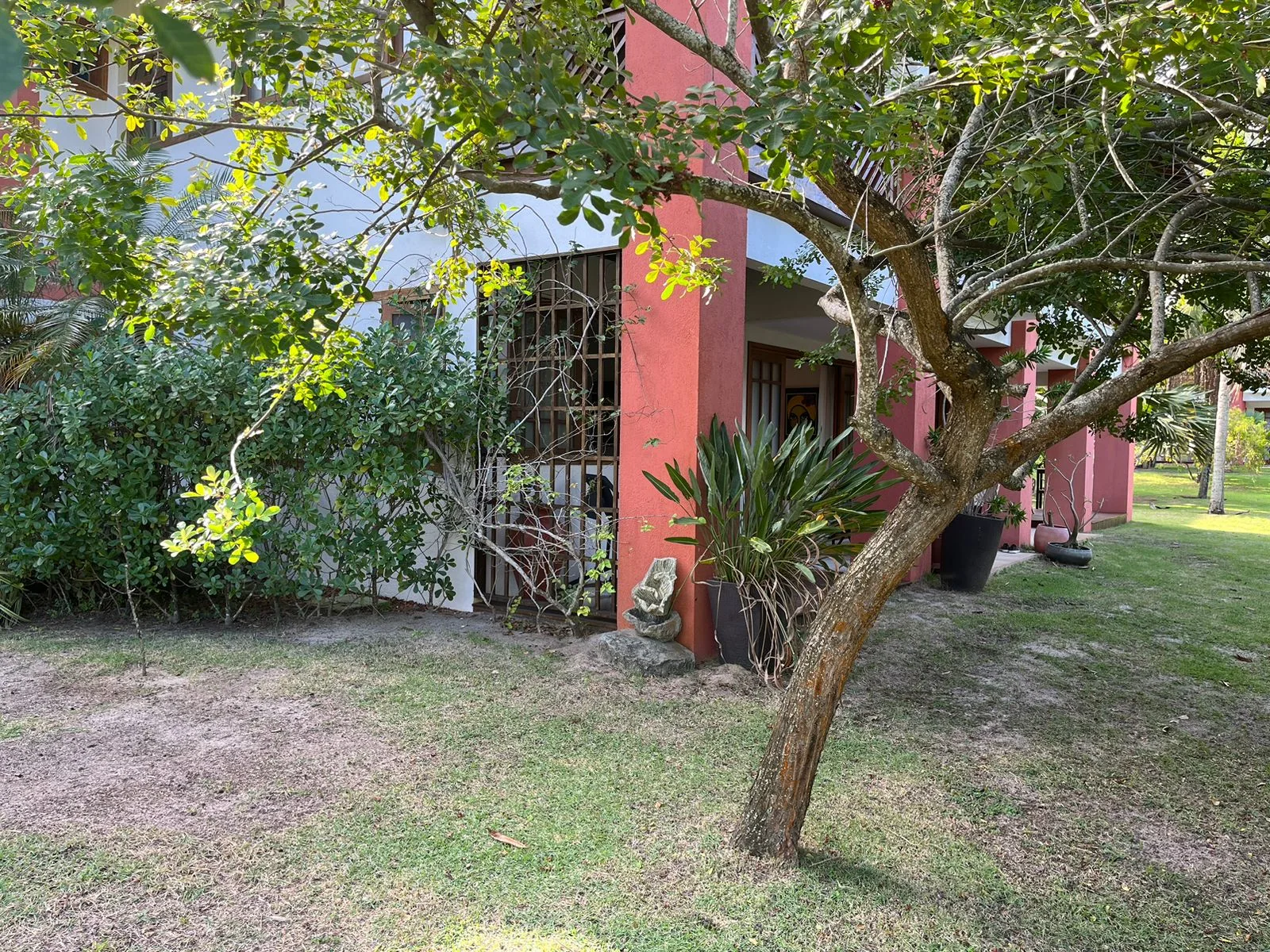 Fachada do apartamento Reserva Timeantube entre árvores e jardim